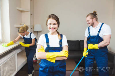 在工作過程中使用專業設備的清潔服務。專業的小廚房清潔, 沙發干洗, 窗戶和地板清洗。穿制服、工作服和橡膠手套的男人和女人